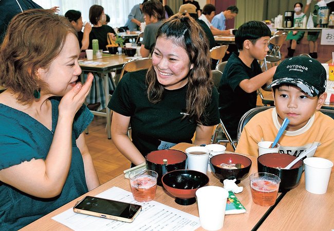 来場者に笑顔で声をかける稲田有咲さん（中央）＝益田市遠田町、安田公民館