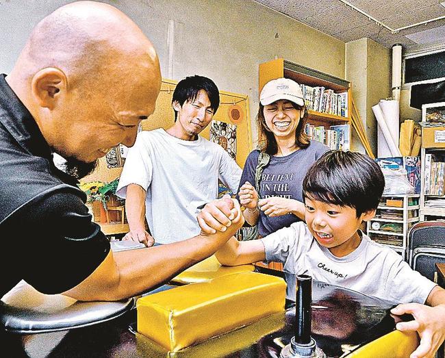 アームレスリングを楽しむ子ども＝松江市八幡町、竹矢公民館