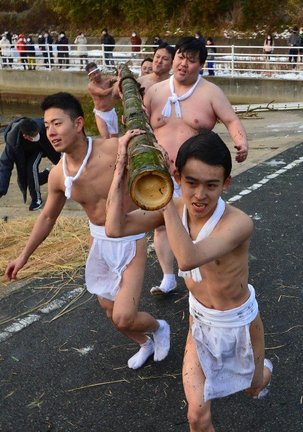 海から運び出した竹を担いで走る男衆＝島根県隠岐の島町今津、今津漁港
