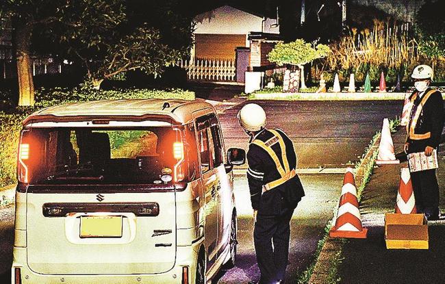 ドライバーにハイビームの視認性を確認してもらい、適切利用を呼びかける大田署員＝大田市久手町