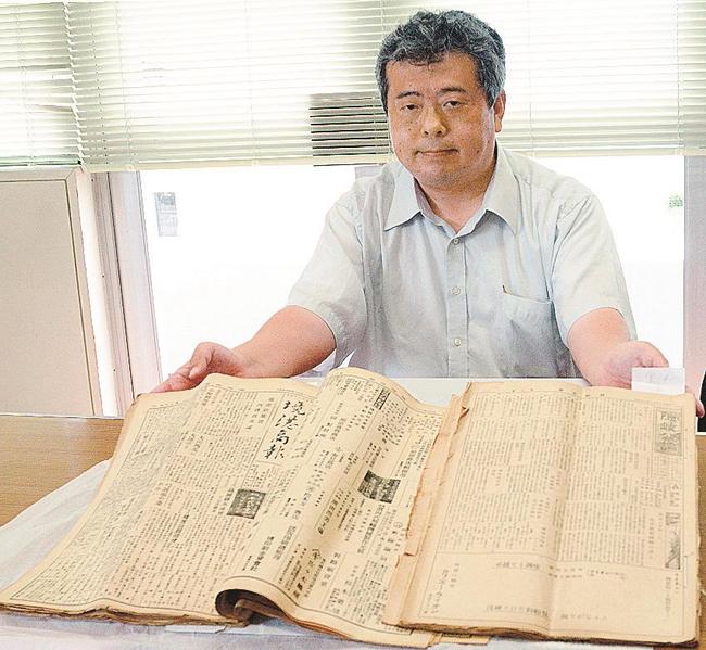 見つかった「境港商報」（左）と「隠岐公論」を手にする舩杉力修准教授＝境港市上道町、市役所