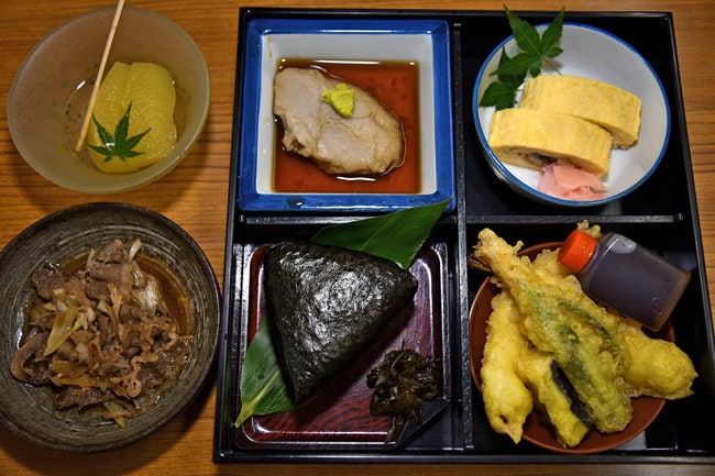 提供された鴎外食。（左上から時計回りに）果物のコンポート、そばがき、うなぎ巻、天ぷら、葉唐辛子のつくだ煮、おにぎり、牛鍋