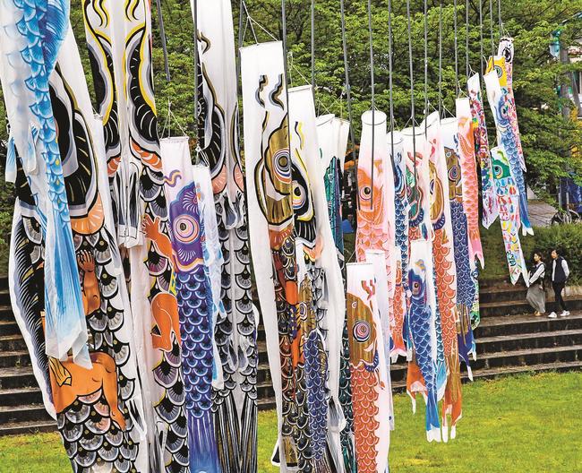 川に掲げられたこいのぼりを楽しむイベント参加者＝松江市八雲町日吉