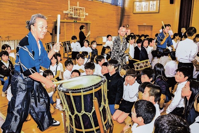 子どもたちの前で太鼓を演奏する「ＡＵＮ＆ＨＩＤＥ」の３人＝大田市久手町、久手小学校
