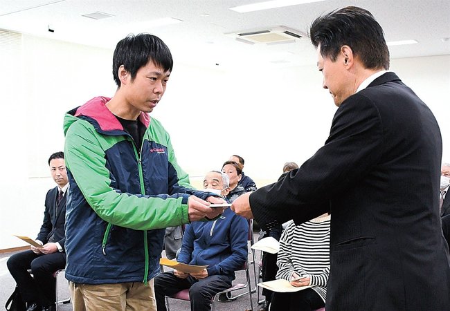 珍部誠本部長（右）から商品券を受け取る子ども食堂代表者＝出雲市今市町、ＪＡしまね出雲地区本部