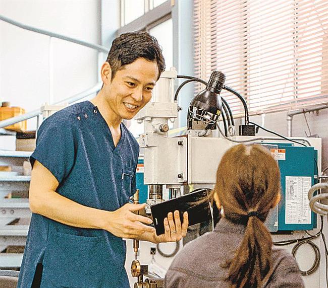 サービス提供先の従業員から作業の実態を聞き取る藤井寛幸社長（左）＝雲南市内