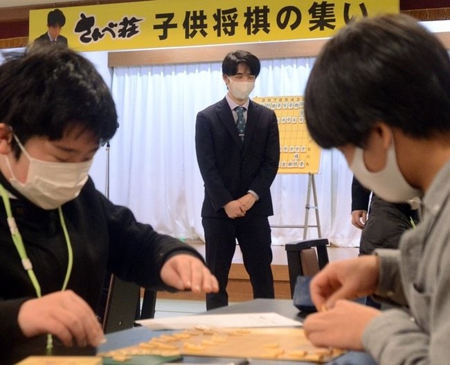 子どもたちの対局を見守る藤井聡太王将（中央）＝大田市三瓶町、国民宿舎さんべ荘