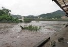 氾濫危険水位を越えた江の川と支流の三谷川（手前）＝１３日午後３時５９分、島根県川本町川本