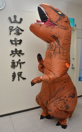 山陰中央新報社の受付でポーズを取るティラノサウルス＝松江市殿町