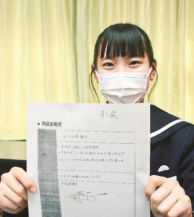 原案を手に商品をＰＲする大屋美羽さん＝浜田市熱田町、浜田商業高校