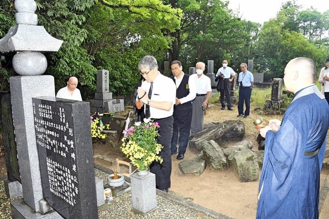 慰霊碑の前で手を合わせる参列者=出雲市大社町杵築南、神光寺