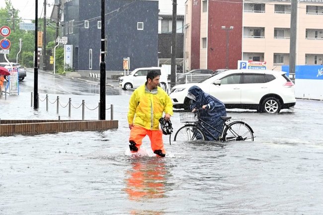 自転車を押して横断歩道を渡る通行人＝９日午後０時３１分、松江市黒田町