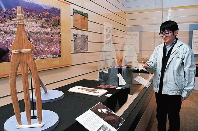 木製のくわなど弥生時代の道具を紹介する野中智学芸員＝出雲市斐川町神庭、荒神谷博物館