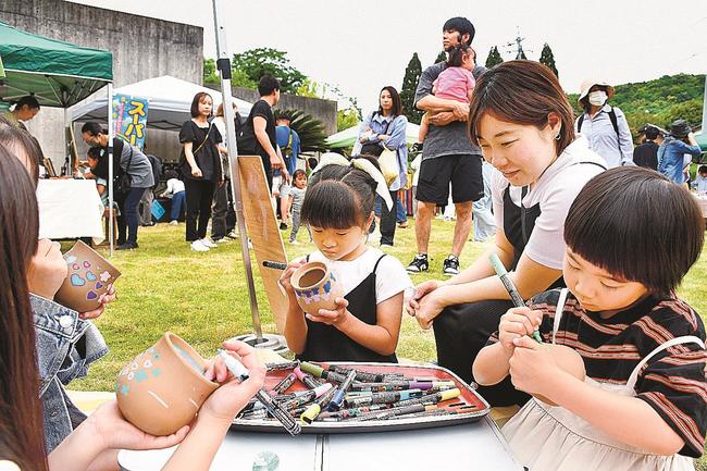 絵付けを楽しむ親子連れ＝松江市玉湯町玉造、玉造温泉ゆ～ゆ屋上広場