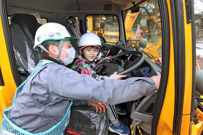 除雪車の運転席に乗り笑顔の園児＝島根県津和野町中座、国土交通省浜田河川国道事務所津和野除雪基地