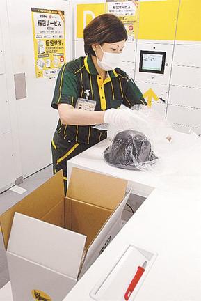 集荷した商品を梱包するヤマト運輸の作業員=30日午後、東京都江東区