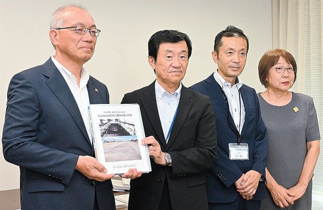 県市町村教育委員会連合会の杉谷学会長(左)に平和教育冊子を贈る島根教師の会メンバー∥出雲市今市町、市役所