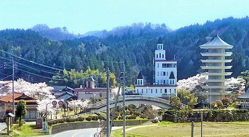 多根良尾が植栽した桜に囲まれた佐白で、良尾の思いを伝えている奥出雲多根自然博物館（中央）と八重の塔の志學荒神社（右側）＝島根県奥出雲町佐白