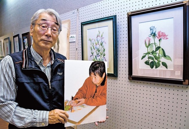 槙野良樹さんのパネルを手に作品を紹介する宍道年弘さん＝出雲市斐川町神庭、荒神谷博物館