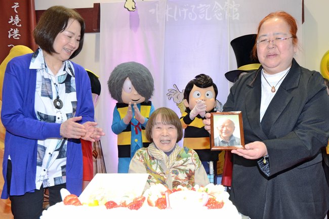 ファンから祝福され笑顔を見せる水木しげるさんの妻・武良布枝さん（中央）と、娘の原口尚子さん（左）、武良悦子さん（右）＝境港市大正町、みなとさかい交流館