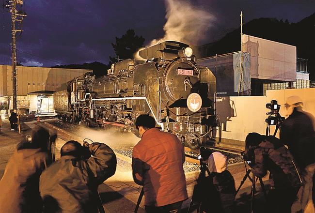 ライトアップされた蒸気機関車を撮影する鉄道ファンや観光客＝島根県津和野町後田、ＪＲ津和野駅