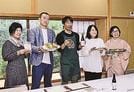 美ビールを持つ石田章代表（中央）と新たに開発したおつまみを持つ玉肌協定の関係者＝出雲市多伎町小田、はたご小田温泉