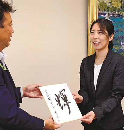 飯塚俊之市長(左)に自筆の色紙を渡し、抱負を述べる里見香奈女流四冠=出雲市今市町、市役所