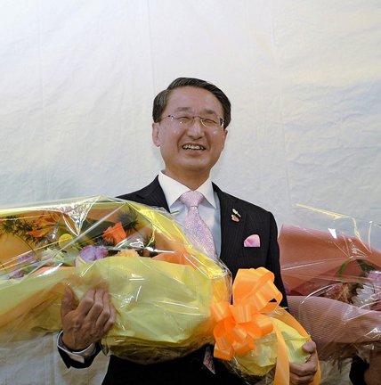 ５選を決め、花束を手にして喜ぶ平井伸治氏＝９日午後８時２８分、鳥取市新町の事務所