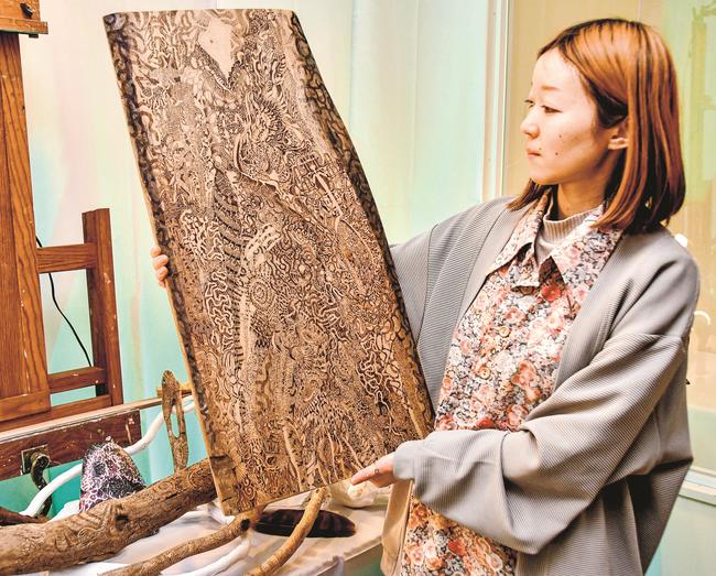 焼き絵作品「この?」を紹介するｌｉｎ圖さん＝鳥取県大山町御来屋、名和公民館
