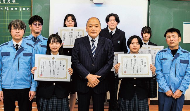 内藤忠社長（中央）と最優秀賞の永田心菜さん（前列右から２人目）ら入賞者＝安来市能義町、情報科学高校