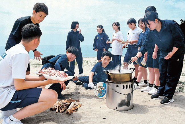 火をおこしてカレーを作り、交流する墨江丘中と西郷南中の生徒たち＝島根県隠岐の島町飯田、塩浜海水浴場