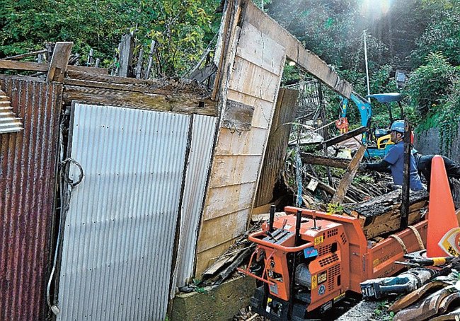 崩壊した特定空き家の解体を進める作業員＝松江市美保関町七類