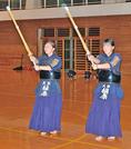 姉の槙原琴音さん（左）とともに素振りに励む栞那さん＝出雲市大社町杵築南、大社小学校体育館
