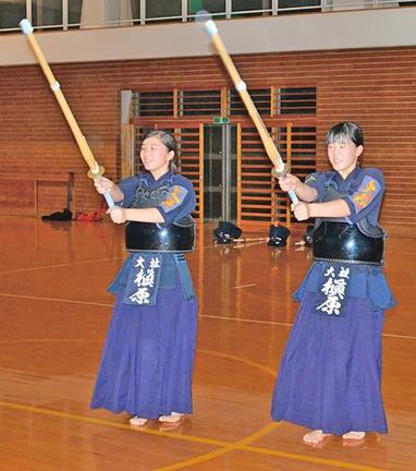 姉の槙原琴音さん（左）とともに素振りに励む栞那さん＝出雲市大社町杵築南、大社小学校体育館