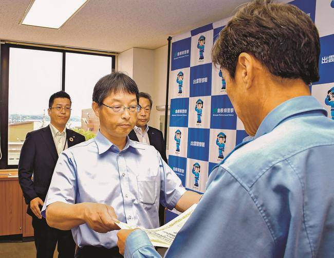 三浦祐明署長（右）から表彰状を受け取る出雲自動車学校の高木寛文校長＝出雲市塩冶有原町２丁目、出雲署
