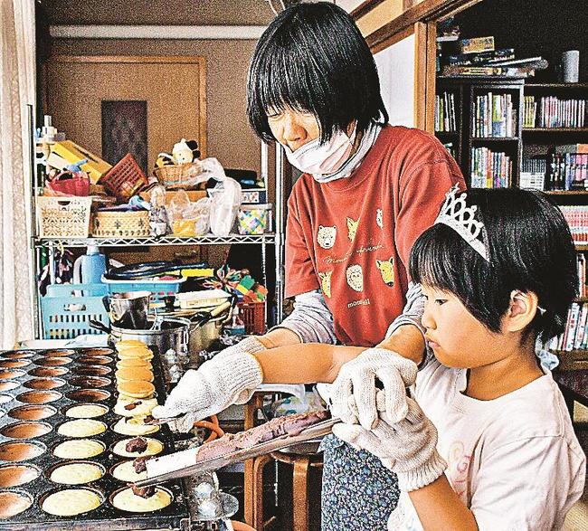 大判焼きにあんこをのせる児童＝浜田市相生町、浜田のまちの縁側