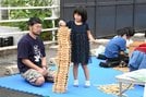 国立三瓶青少年交流の家の出店ブースで、木のおもちゃ遊びを体験する親子