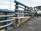 堤防が沈下し、欄干に６０センチの段差ができた妙見橋＝出雲市西園町