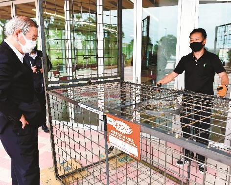 JA職員から、イノシシ捕獲用おりの説明を聞く山下修市長(左)=江津市江津町、市役所