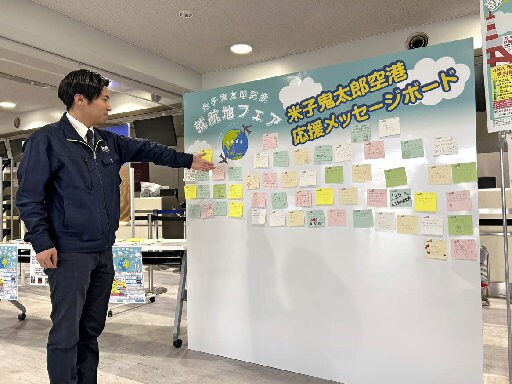 応援メッセージを掲示するボードを紹介する米子空港ビル職員=境港市佐斐神町、米子空港(提供)