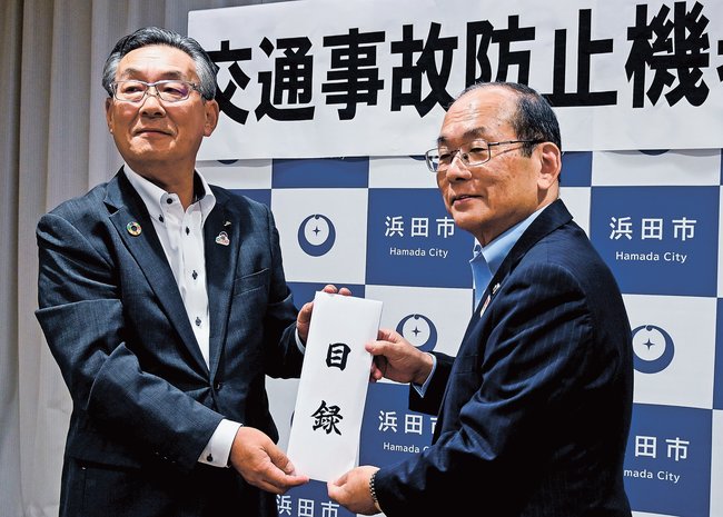 久保田章市市長（右）に目録を手渡す佐々木豊本部長＝浜田市殿町、市役所