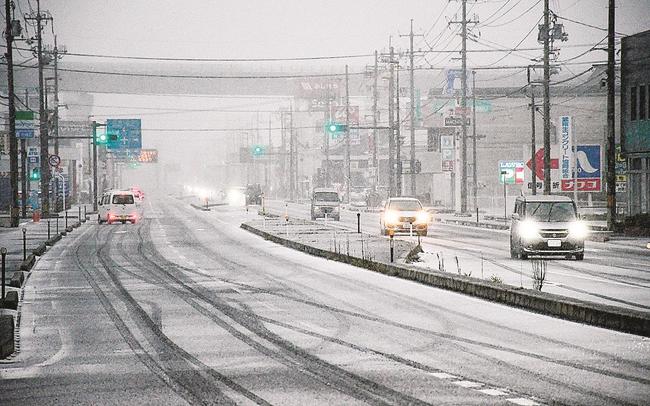 あられが降り、一瞬で白くなった国道５４号＝１８日午前８時１１分、雲南市三刀屋町下熊谷（画像を一部加工しています）