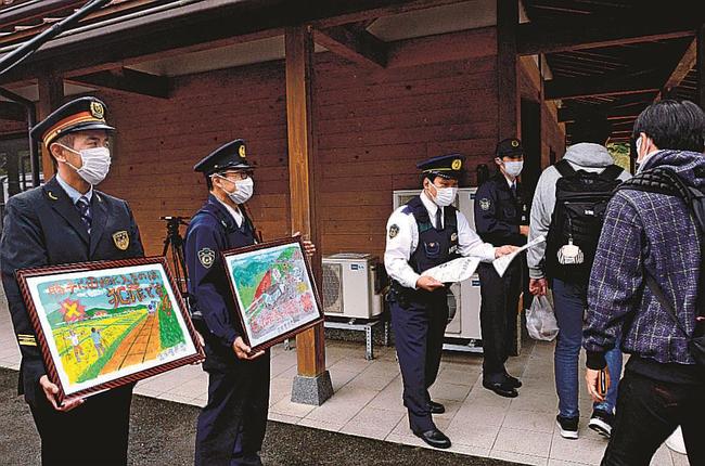 啓発チラシを配布し、マナー順守を呼び掛ける雲南署員ら＝島根県奥出雲町八川、ＪＲ出雲坂根駅