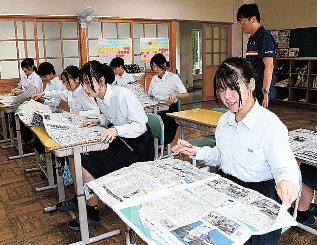 新聞を開いて情報を探す生徒たち＝益田市白上町、中西中学校