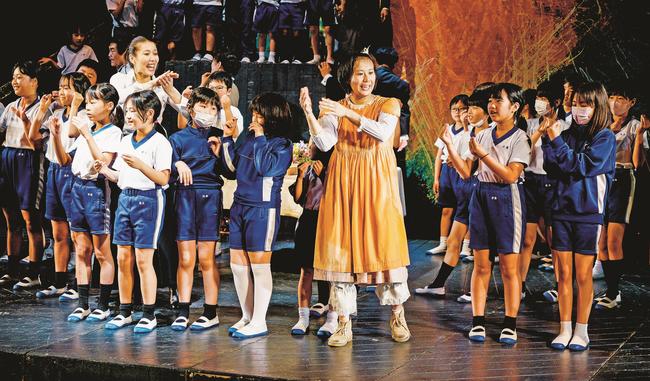 舞台上で俳優と一緒に歌う児童たち＝島根県美郷町都賀西、大和小学校