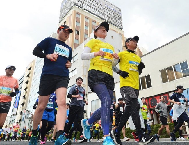 ＪＲ松江駅近くのビル街を駆け抜ける選手＝松江市朝日町