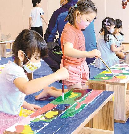 木製のプランターカバーに色を塗る園児＝大田市長久町、サンチャイルド長久さわらび園