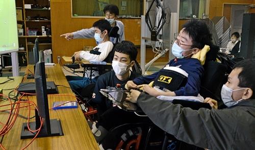 操作の手ほどきを受けながらゲームを楽しむ生徒たち＝松江市上乃木５丁目、松江緑が丘養護学校