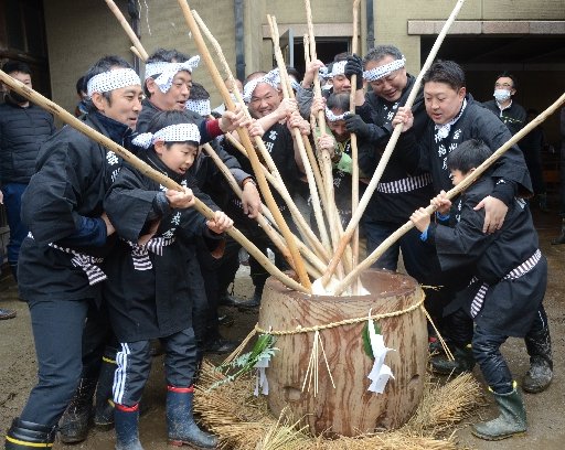 体をぶつけ合いながら、長いきねで餅をこね回す男衆＝雲南市吉田町吉田、田部家