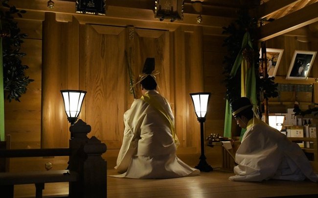 「お立ち」と唱えながら梅の枝で扉をたたき、神々に出発の時を知らせる錦田剛志宮司＝出雲市斐川町併川、万九千神社